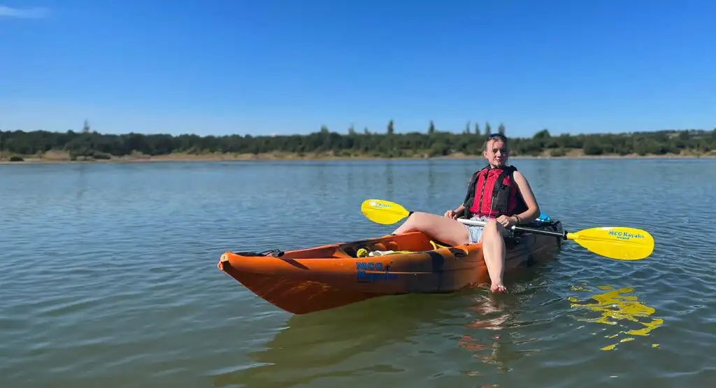 A kayaker taking a break on the shore at Fota Island Adventure, with their kayak resting on the sand.