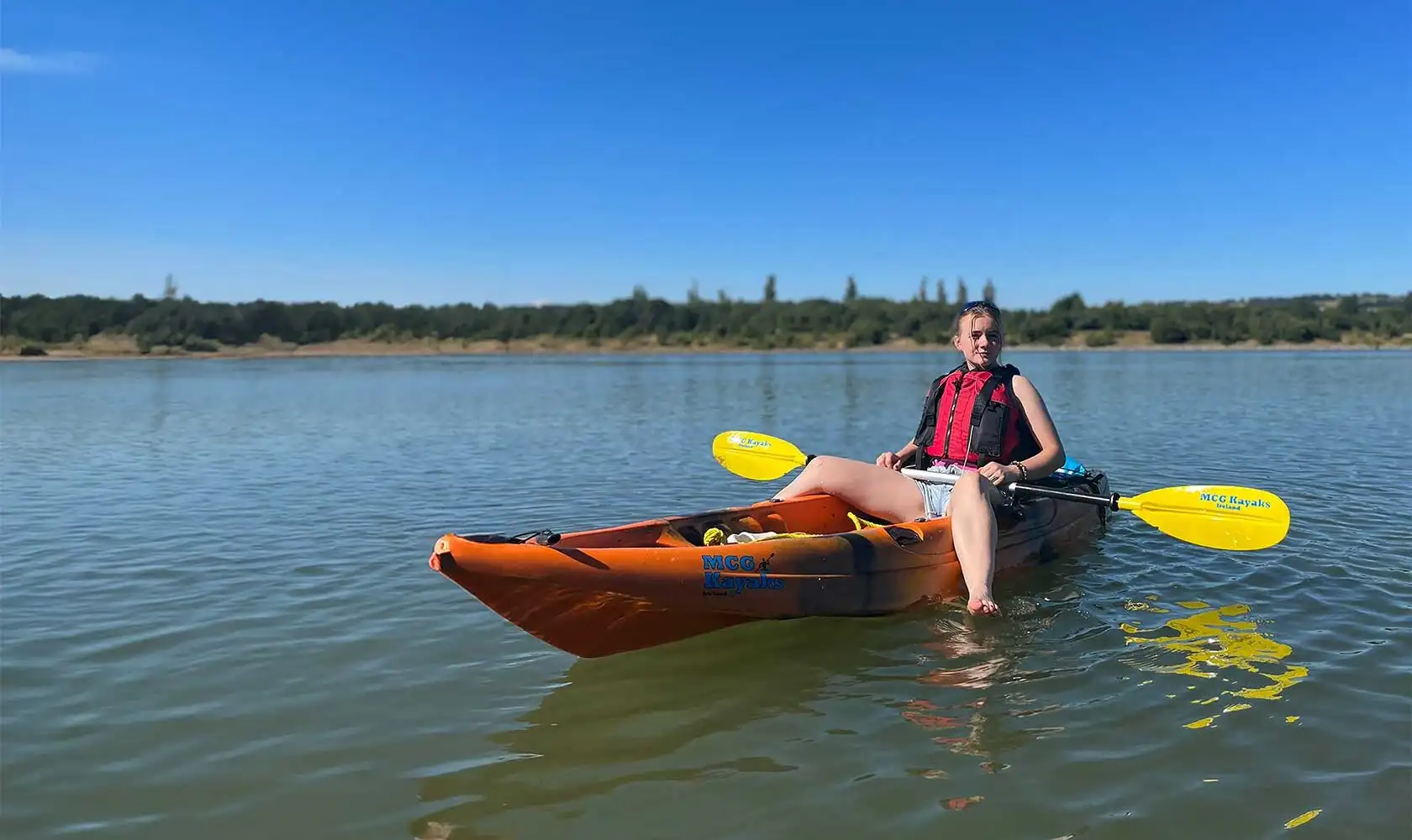 A kayaker taking a break on the shore at Fota Island Adventure, with their kayak resting on the sand.