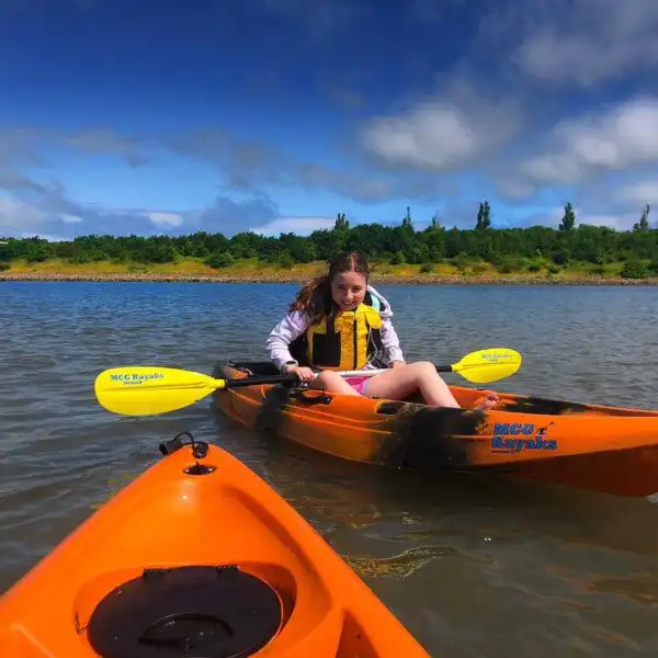 Kayakers navigating through a series of small rapids at Fota Island Adventure, showcasing their skills.