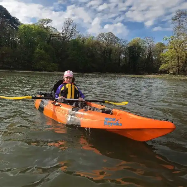 A kayaker enjoying a peaceful moment on the lake at Fota Island Adventure, with a serene landscape.