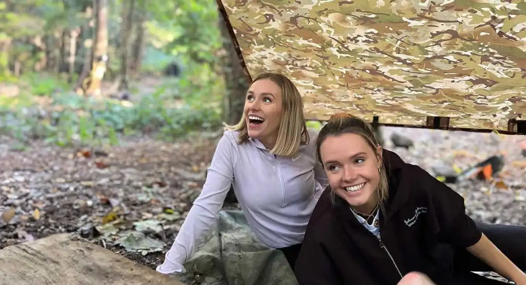 Participants at Fota Island Adventure orienteering event, checking their maps while standing near a checkpoint in a scenic outdoor setting.