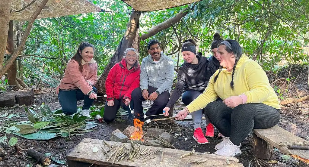 A group of people participating in an orienteering event at Fota Island Adventure, navigating through a forested area with maps in hand.