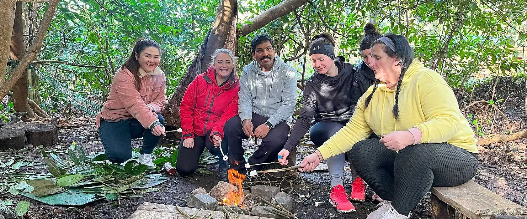 A group of people participating in an orienteering event at Fota Island Adventure, navigating through a forested area with maps in hand.