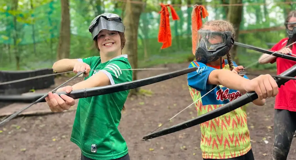 A wide-angle view of school children engaged in a team-building exercise at Fota Island Adventure, showcasing the lush surroundings and group dynamics