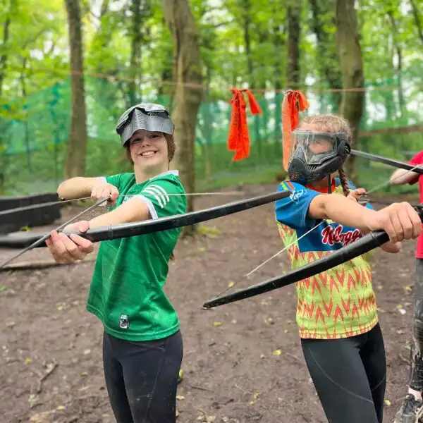 A wide-angle view of school children engaged in a team-building exercise at Fota Island Adventure, showcasing the lush surroundings and group dynamics