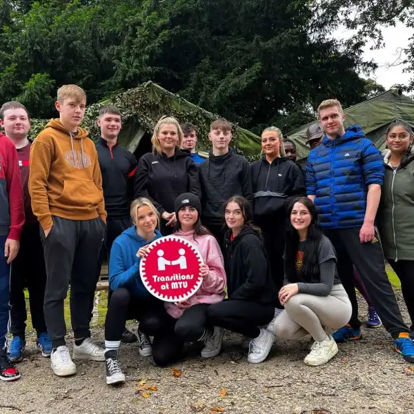 A group of school children participating in a team-building exercise at Fota Island Adventure, with lush greenery in the background.