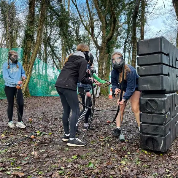 A group of students paddling in a canoe on a calm lake at Fota Island Adventure.