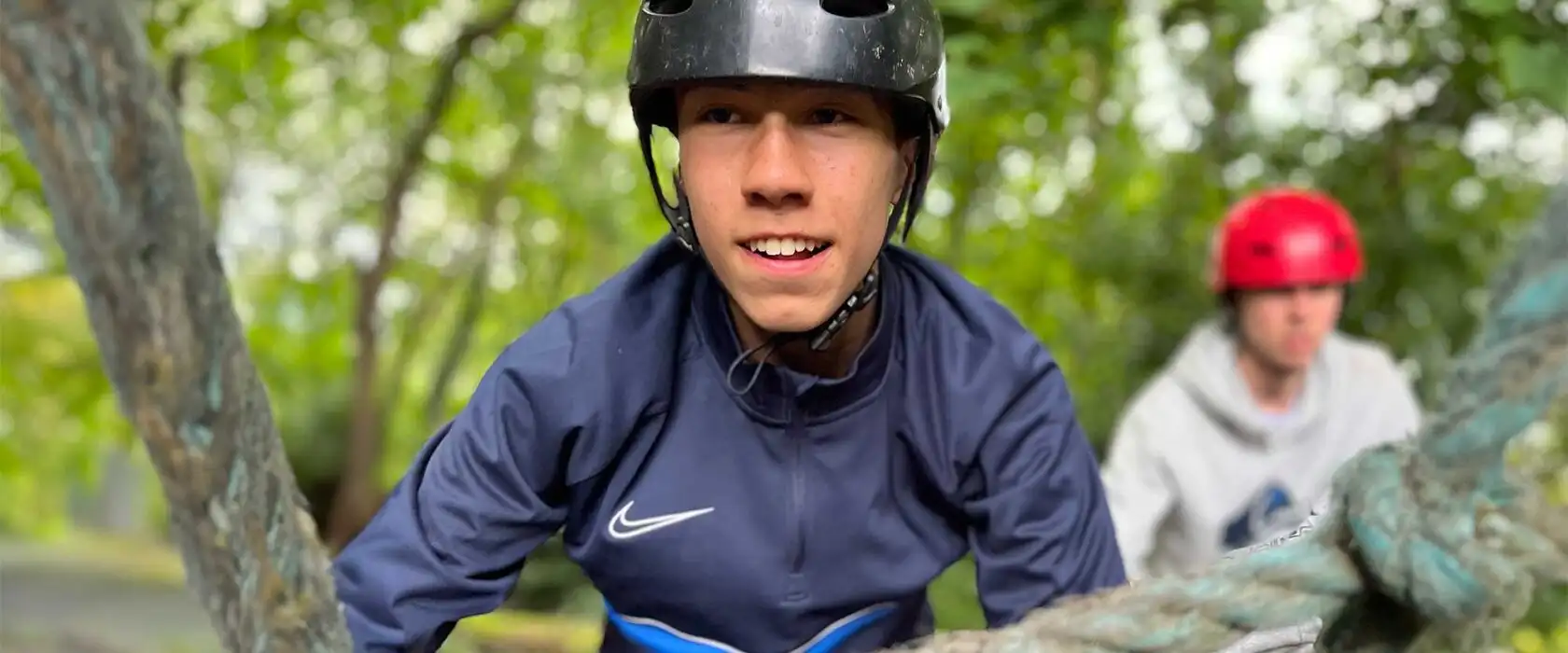A group of colleagues participating in a team-building exercise at Fota Island Adventure, involving a ropes course challenge.