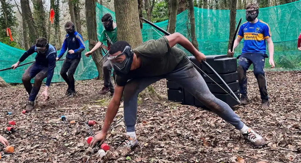Team members collaborating on a problem-solving activity at Fota Island Adventure, set in a scenic outdoor environment.