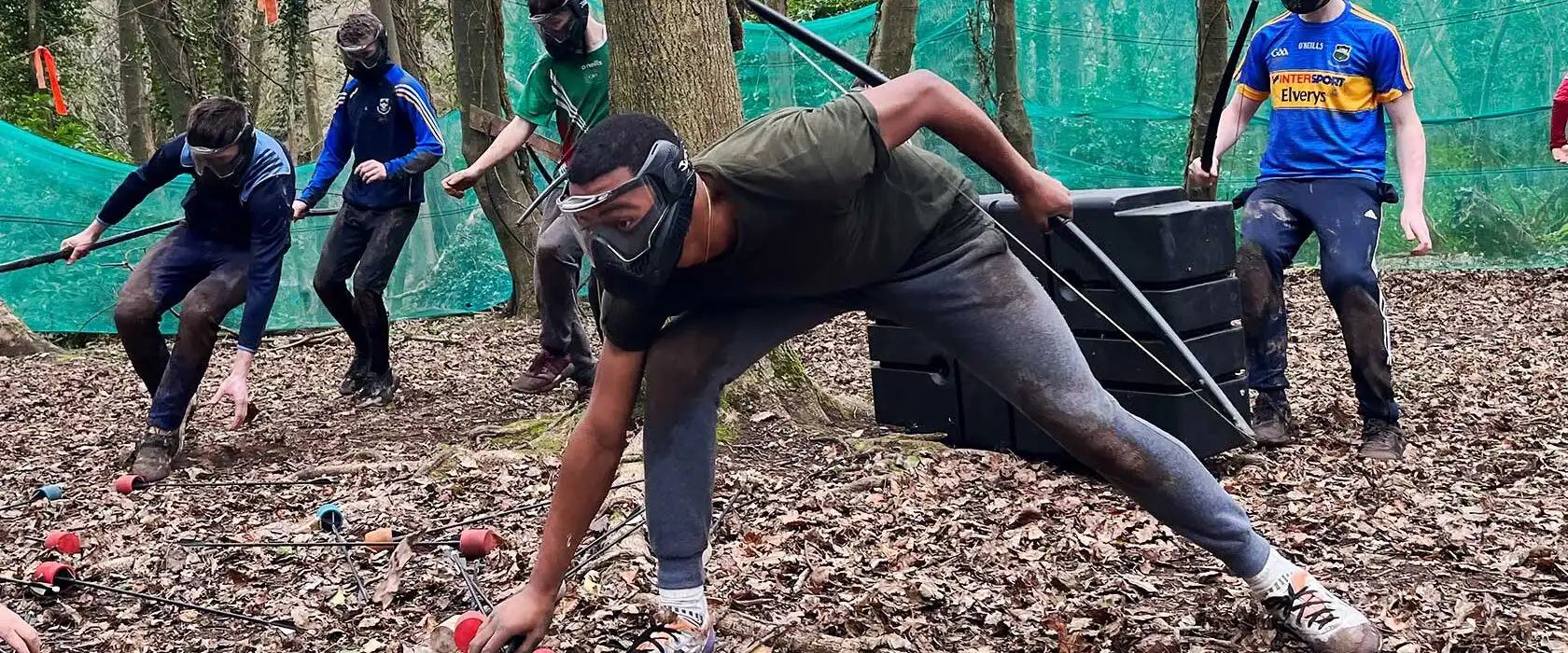 Team members collaborating on a problem-solving activity at Fota Island Adventure, set in a scenic outdoor environment.