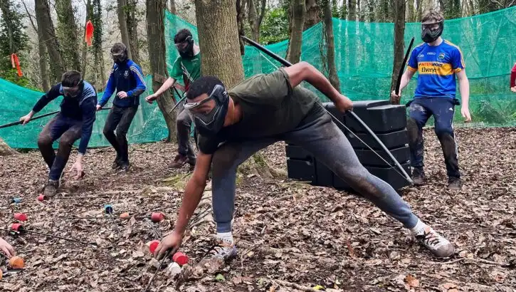 Team members collaborating on a problem-solving activity at Fota Island Adventure, set in a scenic outdoor environment.