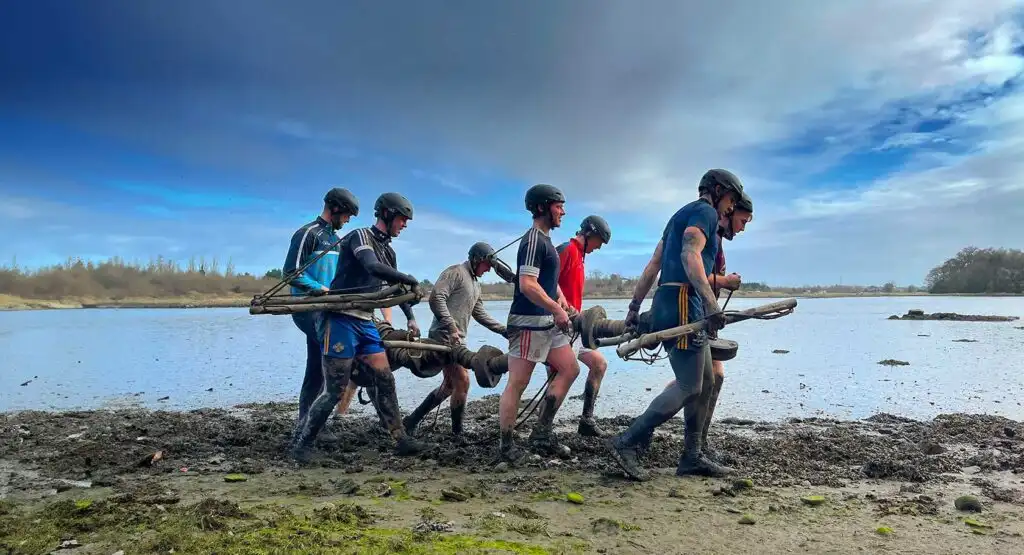 Team members at Fota Island Adventure engaged in a trust-building activity, where one person is blindfolded and guided by others.