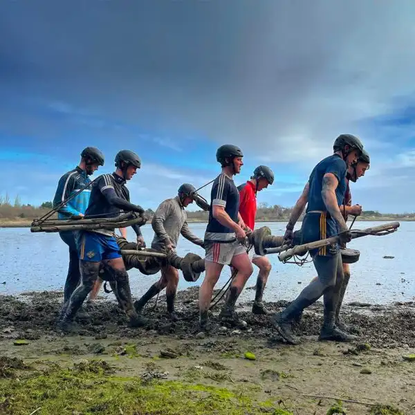 Team members at Fota Island Adventure engaged in a trust-building activity, where one person is blindfolded and guided by others.